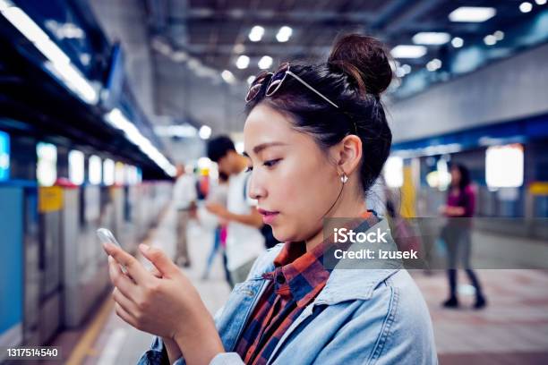 Woman Using Mobile Phone At Subway Platform Stock Photo - Download Image Now - 20-24 Years, Adult, Adults Only
