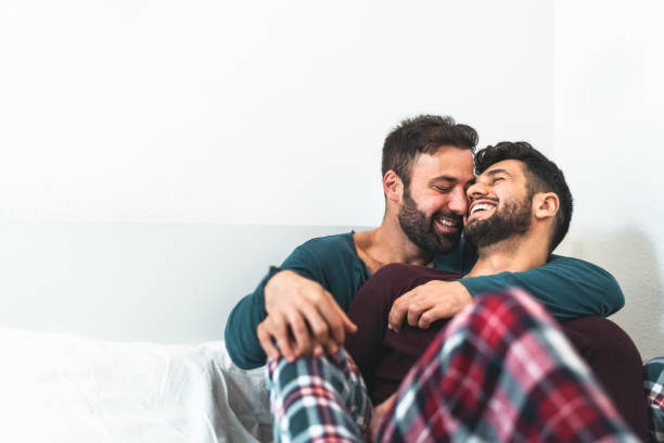 glückliches homosexuelles paar mit zärtlichen momenten im schlafzimmer - homosexuelle liebesbeziehung und gleichstellungskonzept - homosexuelles paar stock-fotos und bilder