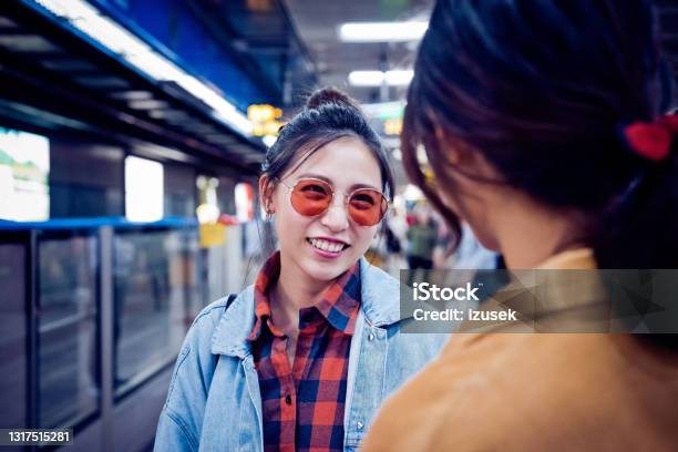Smiling Woman With Friend At Subway Station Stock Photo - Download Image Now - People, Subway, Talking