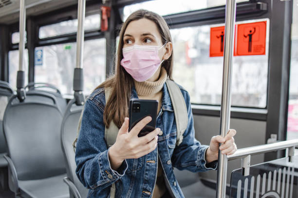 istock Woman with a protective face mask is using mobile phone in public transport 1317515956