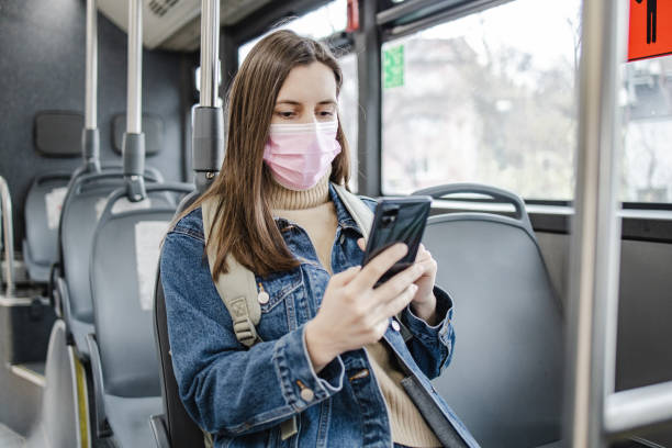istock Woman with a protective face mask is using mobile phone in public transport 1317515970