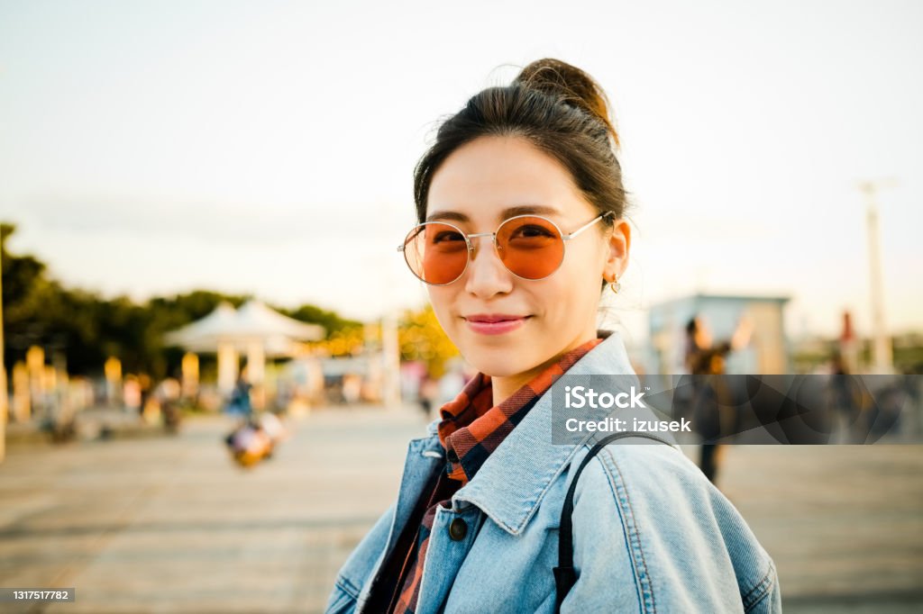 Smiling woman on city break during weekend Portrait of smiling woman on street. Young female is spending weekend in city. She is wearing sunglasses. 20-24 Years Stock Photo