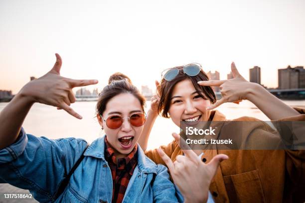 Carefree Female Friends Enjoying City Break Stock Photo - Download Image Now - 20-24 Years, Adult, Adults Only