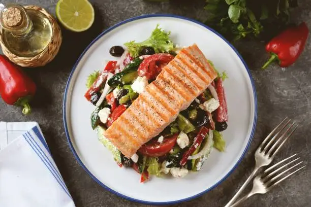 Greek salad with grilled salmon. Healthly food.
