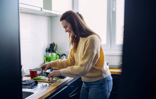 istock Smiling Woman Cooking Lunch in Modern Kitchen 1317518788