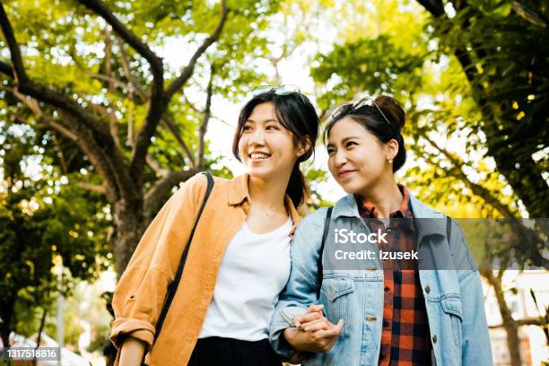 Young Female Friends In Park During Weekend Stock Photo - Download Image Now - 20-24 Years, Adult, Adults Only