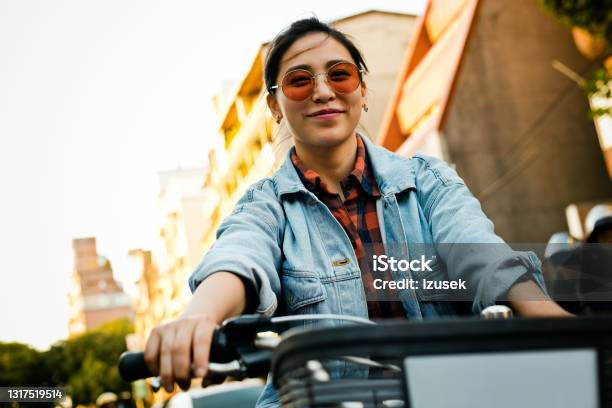 Smiling Young Woman Riding Bicycle In City Stock Photo - Download Image Now - 20-24 Years, Adult, Adults Only