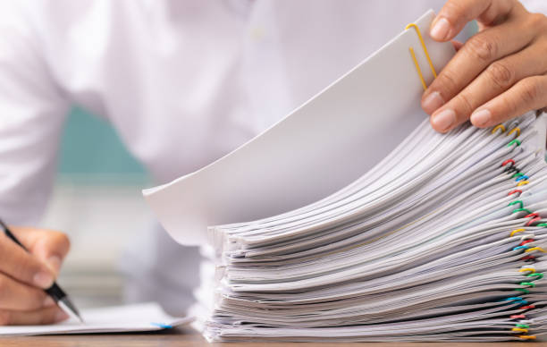 istock Business man hand pick up Stack overload document report paper with colorful paperclip, business and paperless concept, selectived focus 1317520406