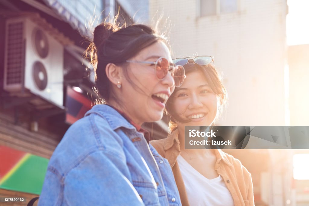 Cheerful female friends enjoying city break Happy young women exploring city. Female friends are enjoying weekend together. They are spending leisure time. 20-24 Years Stock Photo