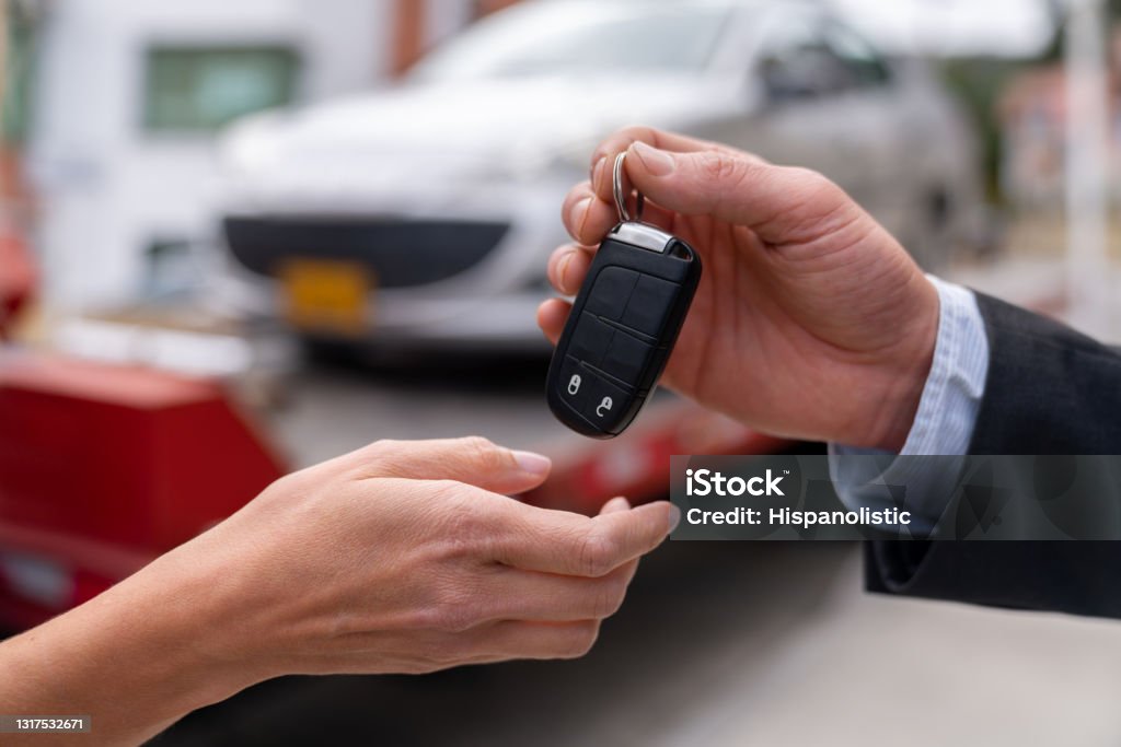 Close-up on a salesman delivering a car while handling the keys Close-up on a salesman delivering a car while handling the keys - car ownership concepts Car Stock Photo