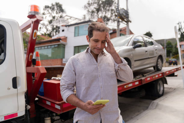 Man having problems with his car and calling roadside assistance Man having problem with his car and calling roadside assistance to take his vehicle to the auto repair shop - roadside assistance concepts transporter stock pictures, royalty-free photos & images