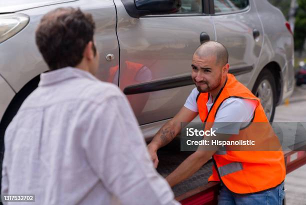 Tow Truck Operator Towing A Car And Feeling Sorry For The Owner Stock Photo - Download Image Now