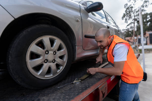 Latin American tow truck operator towing a car Latin American tow truck operator towing a car - roadside assistance concepts tow truck stock pictures, royalty-free photos & images