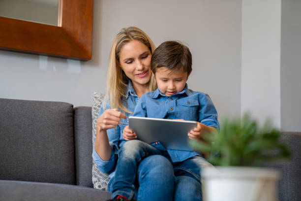 istock Happy mother and son reading a book online using a digital tablet 1317532794