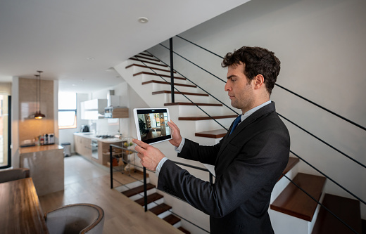 Latin American real estate agent making a virtual tour of a house using a tablet computer - real estate concepts