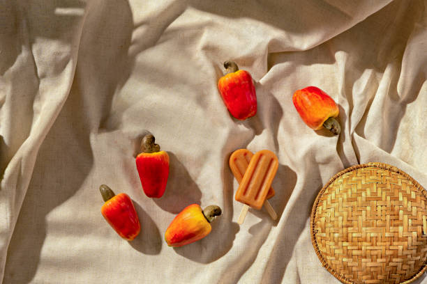 istock Cashew Popsicle with cachew fruits on a fabric base, sunlight, top view 1317532952