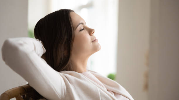 jeune femme paisible détendue avec les yeux fermés respirant l’air frais - air freshener photos et images de collection