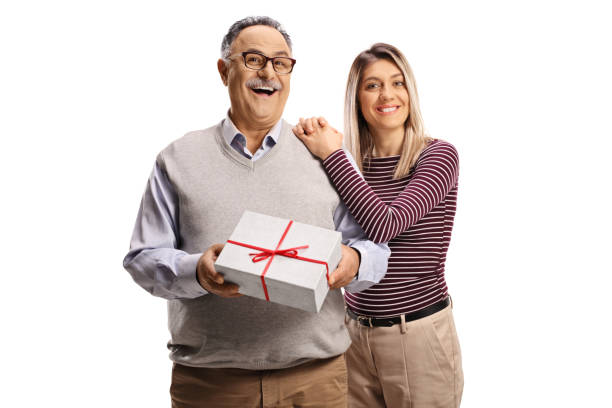 istock Young woman hugging a smiling mature man with a present box 1317540343