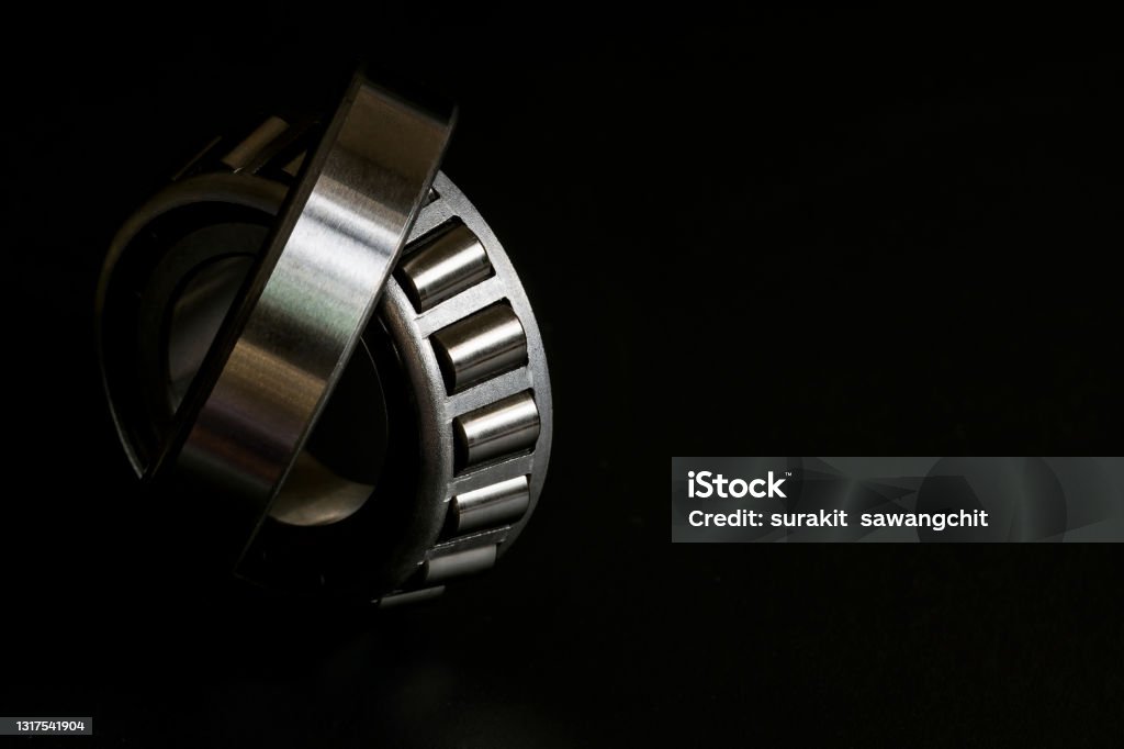 Closeup of Tapered roller bearing on black background, Spare part of mechanical industry. Car Stock Photo