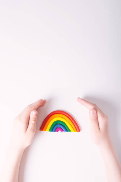 istock KId's hands around plasticine rainbow. Top view. 1317542033