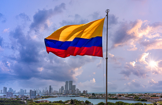 Flag wavering in front of scenic view of Cartagena modern skyline near historic city center and resort hotel zone.