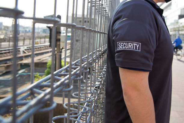 Security guard in uniform patrolling residential area nearby railway. A view of a security guard in uniform patrolling a residential area nearby railway. security guard photos stock pictures, royalty-free photos & images