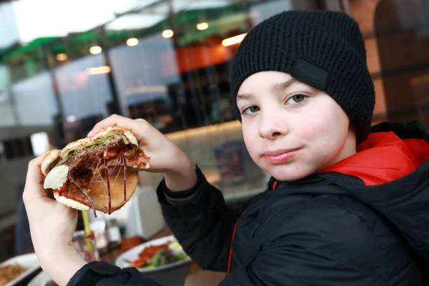 istock Child has burger on restaurant terrace 1317551086