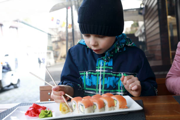 istock Child taking sushi with chopsticks 1317551112