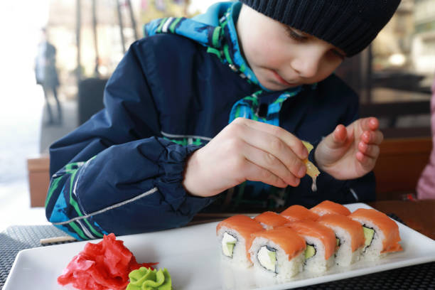 istock Child squeezes lemon juice on sushi 1317551114