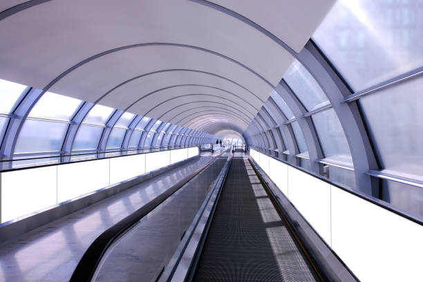 istock Visual mockup for advertising banner display on moving walkway travelator in long pedestrain tunnel. Blank billboard advertising space for mock up purpose; OOH in situ ad placement. 1317552840
