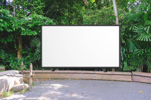 straight front angle of large empty wooden signboard for advertising, map display or mockup comping purpose. lush green background behind blank display billboard - park sign imagens e fotografias de stock