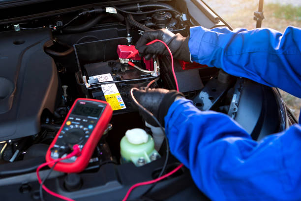 le technicien utilise le voltmètre multimètre pour vérifier le niveau de tension dans la batterie de voiture. batterie de voiture de service et d’entretien. - digital voltmeter photos et images de collection