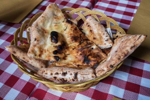 Sliced focaccia in a wicker basket on the table. Restaurant in Rome, Italy.