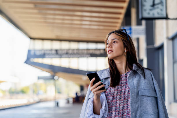 istock Young woman waiting on station and using smart phone 1317554408