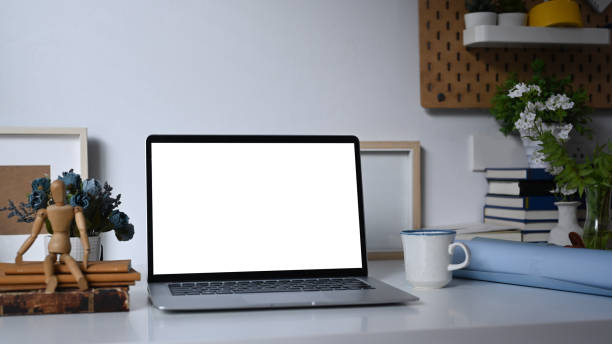 istock A computer laptop with empty screen and office supplies on white table. 1317555499