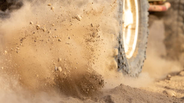 movimiento de las ruedas neumáticos fuera de la nube de polvo de la carretera en el desierto, vehículo offroad golpeando a través de la arena en el desierto. - sports utility vehicle 4x4 car tire fotografías e imágenes de stock