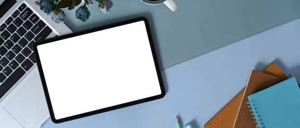 istock Top view digital tablet with white screen, laptop and notebook on blue leather. 1317556110