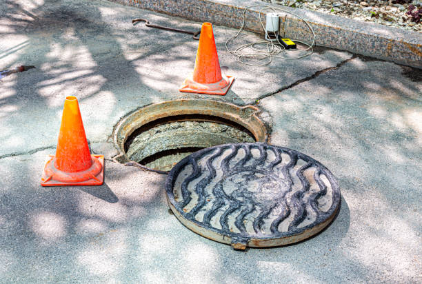 Open sewer manhole on the asphalt road Open sewer manhole on the asphalt road. Accident with sewer hatch in city. Concept of sewage, repair of underground communications sewer lid stock pictures, royalty-free photos & images