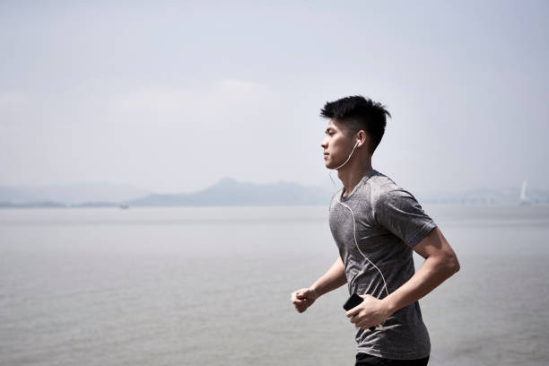 istock young asian man running by the sea 1317559217