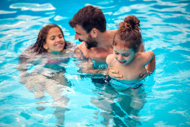 istock Father with kids playing in the pool.  Fun with kids. 1317560233