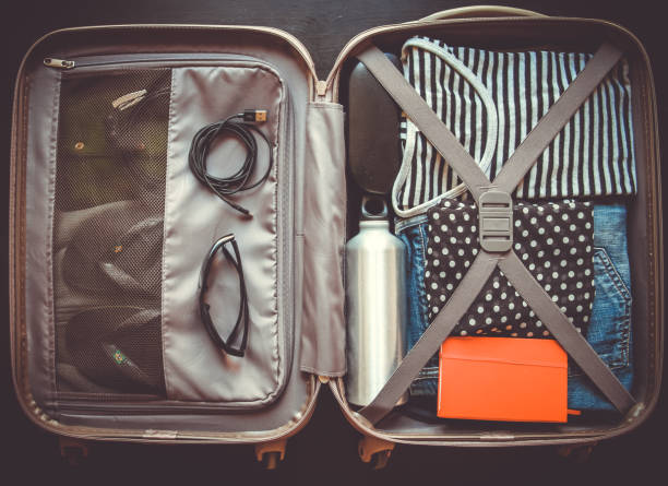 istock Open suitcase full of clothes isolated on black background 1317561498