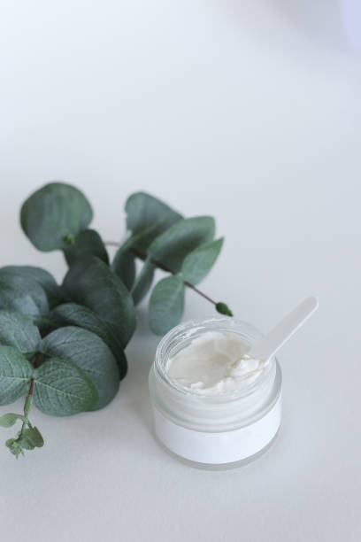 istock Moisturizing cosmetic cream with eucalyptus stands on neutral background with milk splash 1317562218