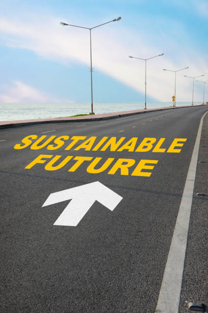 istock Sustainable future word on asphalt road surface with white arrow and marking lines on beach background 1317564864
