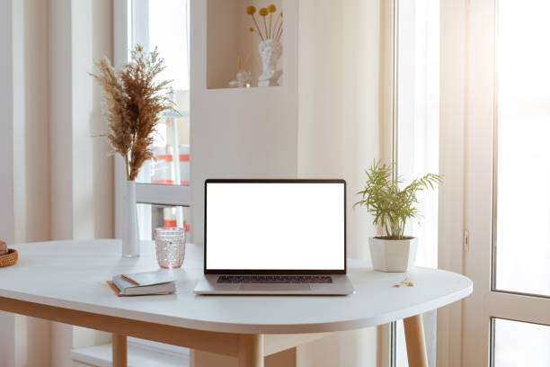 istock Laptop with blank white screen in office desk interior. Stylish workplace mockup. 1317566054