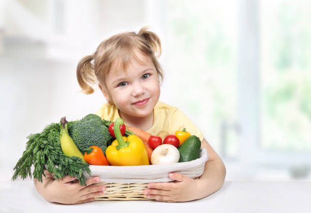 新鮮な果物や野菜のバスケットを持つ子供。子供の健康的な栄養。エコ生鮮食品コンセプト。 - vegies vegetable basket residential structure ストックフォトと画像