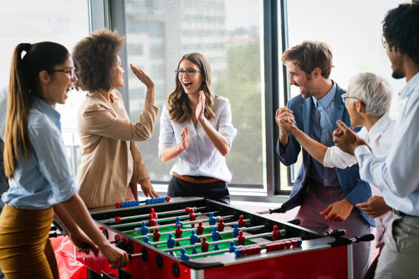 istock Colleagues playing table football in the break. 1317570299