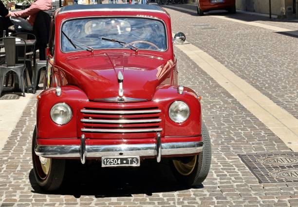Vintage car Fiat 500 C Topolino parked In a street of the town. Monfalcone, Italy. May 10, 2021. Shiny red Fiat 500 C Topolino  parked In a street of the town. It is the famous vintage car of the italian automaker produced from Forties fiat 500 topolino stock pictures, royalty-free photos & images