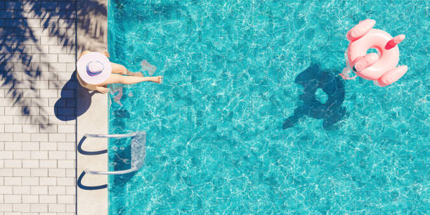 aerial view of woman sitting on the pool - beira dágua imagens e fotografias de stock