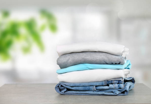 istock Cotton folded clothes on table indoors. Clean apparel stacked. Stack of clothing. 1317573783