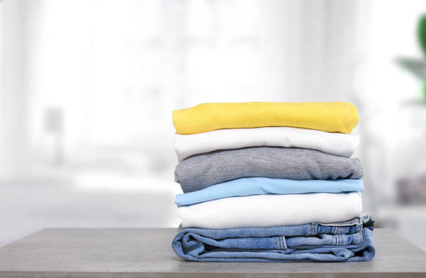 stack of cotton colorful clothes on table indoors.stacked apparel.folded clean clothing. - monte roupa imagens e fotografias de stock